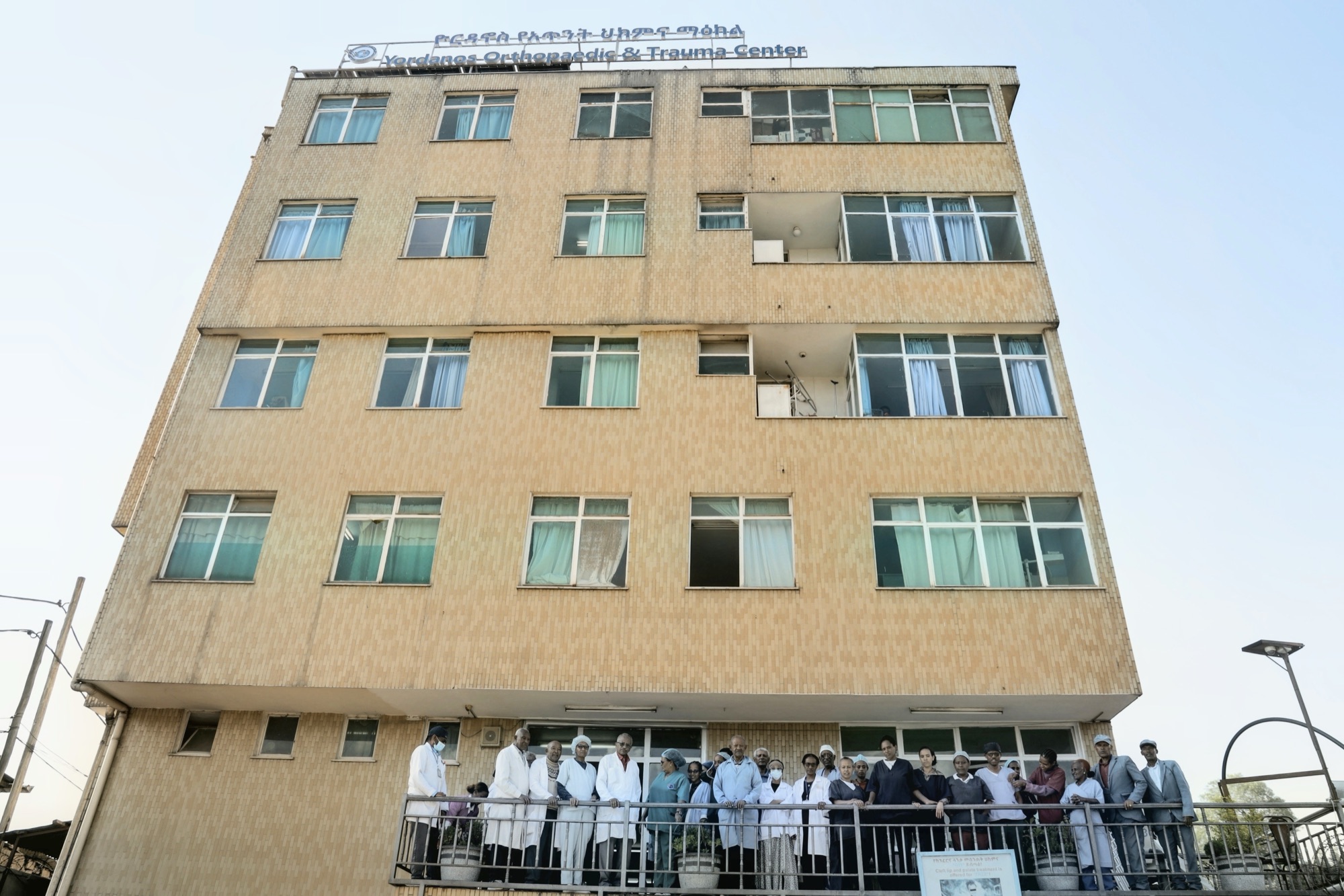 The Yordanos Hospital building with doctors, nurses, and staff gathered on the balcony